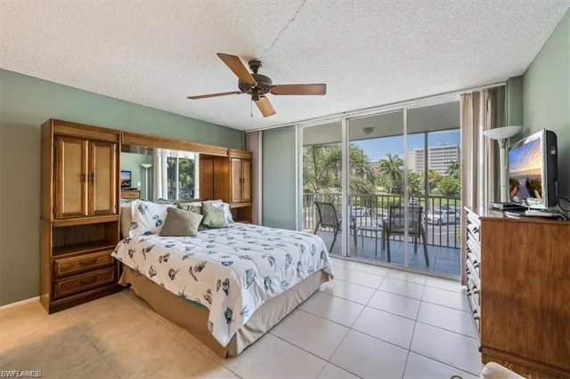 a bedroom with a bed a chair and a large window