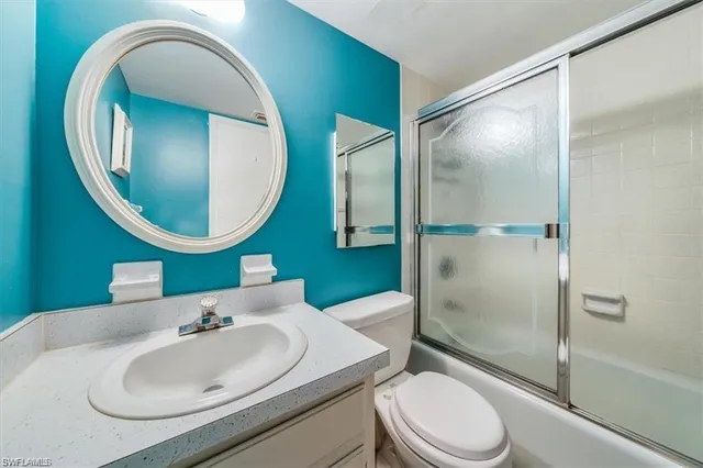 a bathroom with a sink mirror and toilet