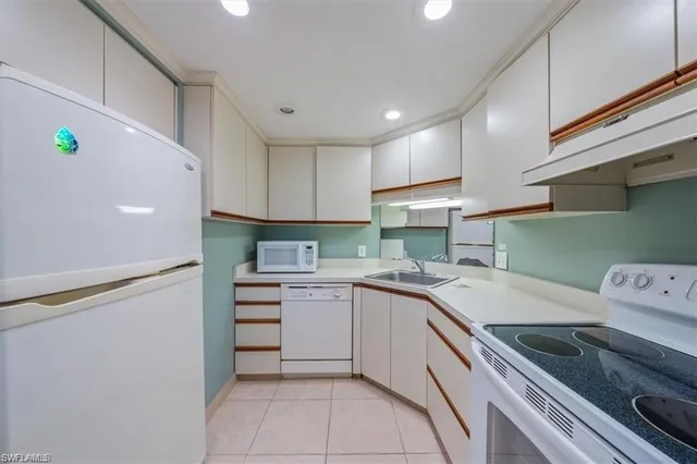 a kitchen with a sink a refrigerator and cabinets