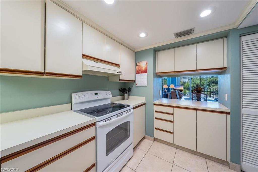 3 Bluebill Avenue, Unit 207 Naples, FL 34108 - Photo 29 of 32 a kitchen with a stove and a refrigerator