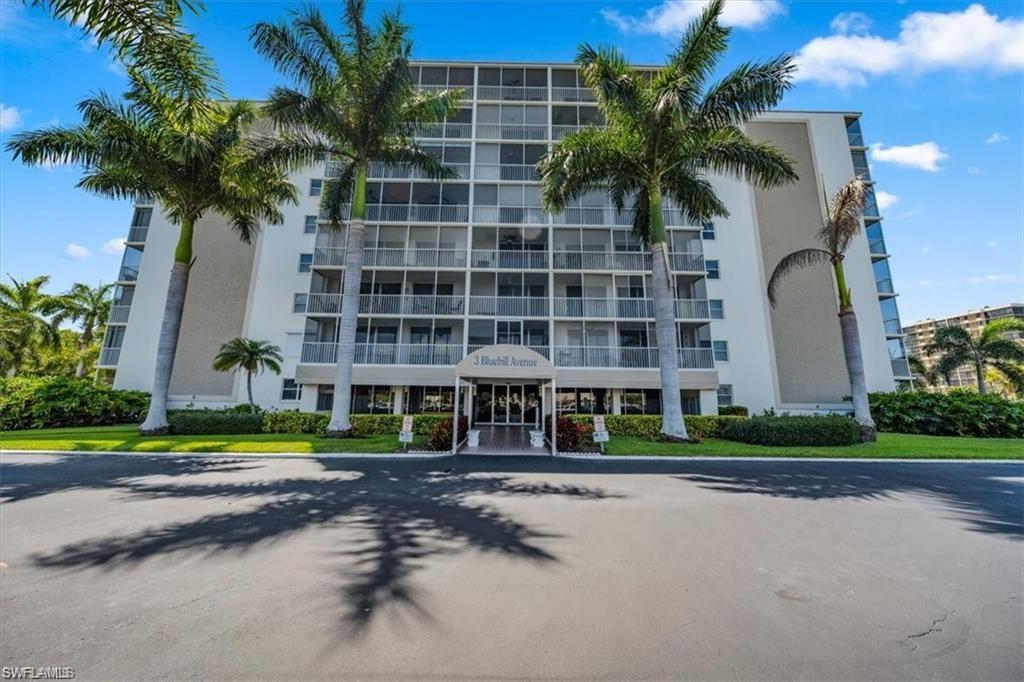 3 Bluebill Avenue, Unit 207 Naples, FL 34108 - Photo 30 of 32 a front view of multi story residential apartment building with yard and green space