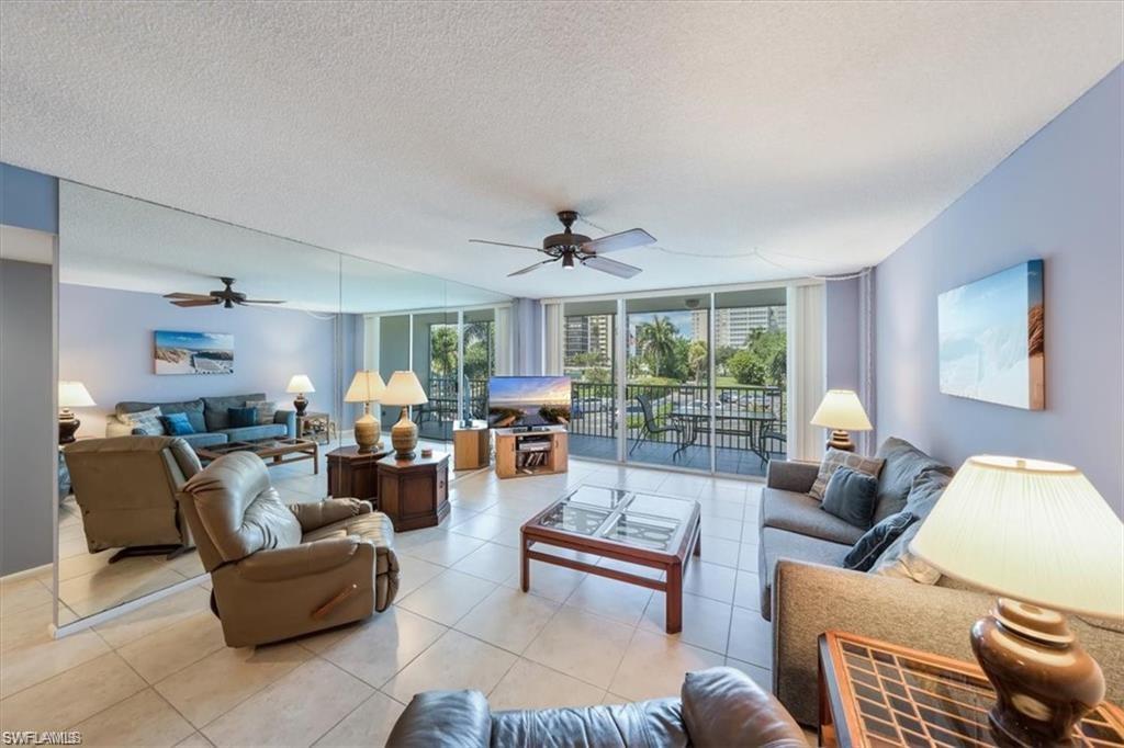 3 Bluebill Avenue, Unit 207 Naples, FL 34108 - Photo 9 of 32 a living room with furniture and a large window