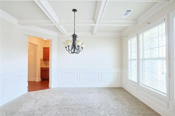 a view of a livingroom with furniture wooden floor and a kitchen