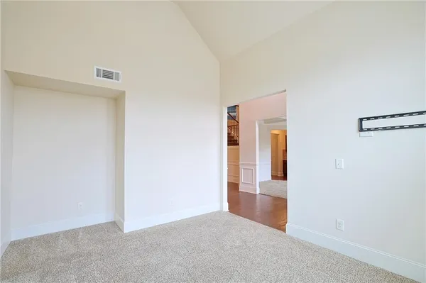 a view of empty room with window and chandelier fan