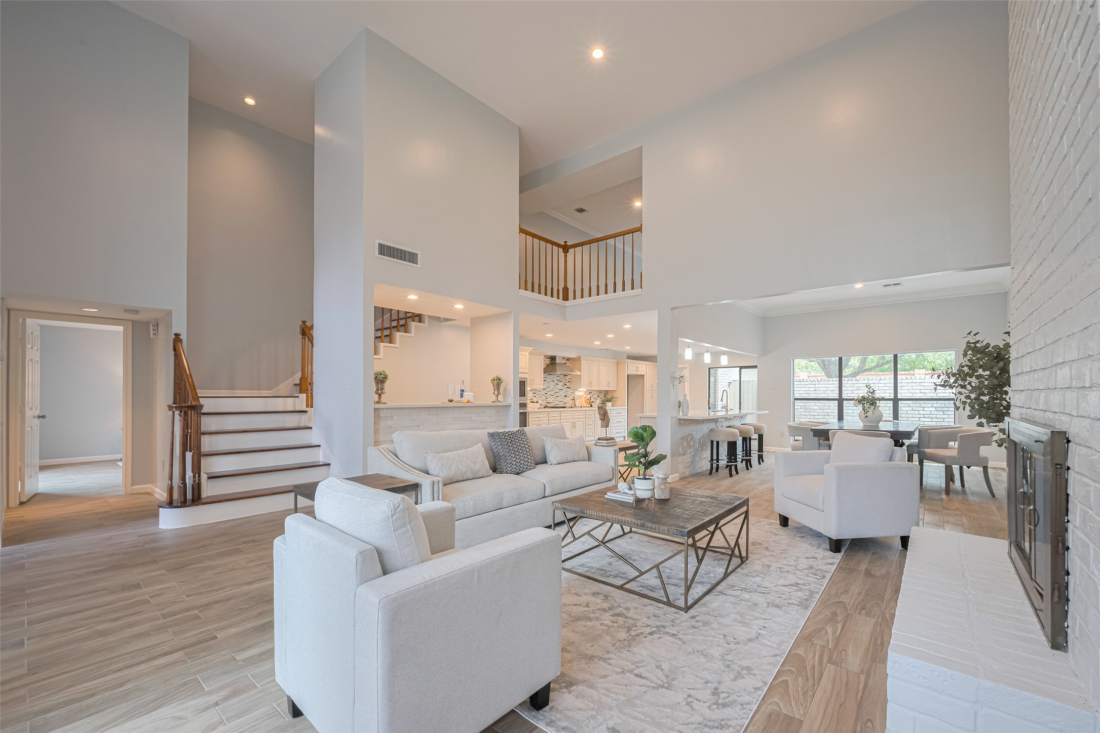 15600 Barkers Landing Road, Unit 20 Houston, TX 77079 - Photo 49 of 49 This spacious living area features high ceilings, modern decor, and an open floor plan that connects to a bright kitchen and dining space. The room is filled with natural light, has a cozy fireplace, and offers a stylish, welcoming atmosphere.