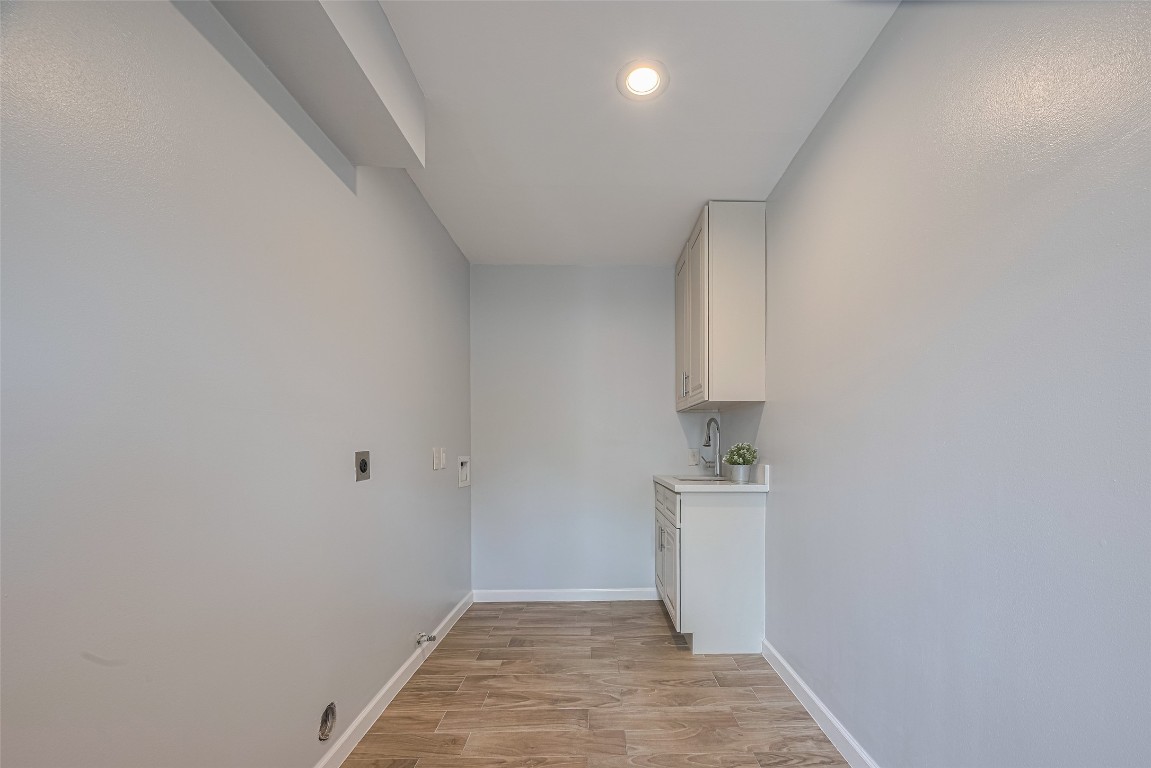 15600 Barkers Landing Road, Unit 20 Houston, TX 77079 - Photo 24 of 49 This photo shows a large laundry room that can accommodate easily a washer & dryer and a secondary fridge. The cabinets and sink provide some functionality to the space. Not seen it's a door that leads to the attached 2 car garage.