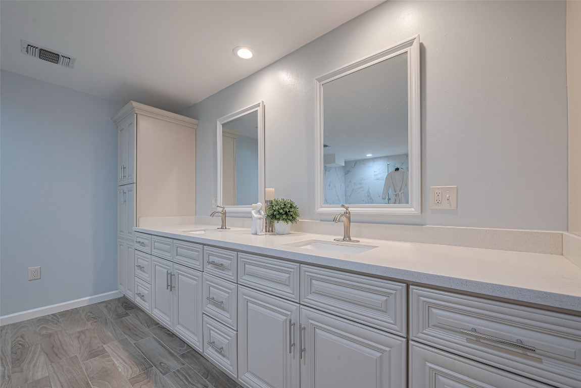 15600 Barkers Landing Road, Unit 20 Houston, TX 77079 - Photo 31 of 49 This bathroom features a dual-sink vanity with elegant faucets, ample storage, and a sleek, modern design. The light color scheme enhances the spacious feel, complemented by modern mirrors.