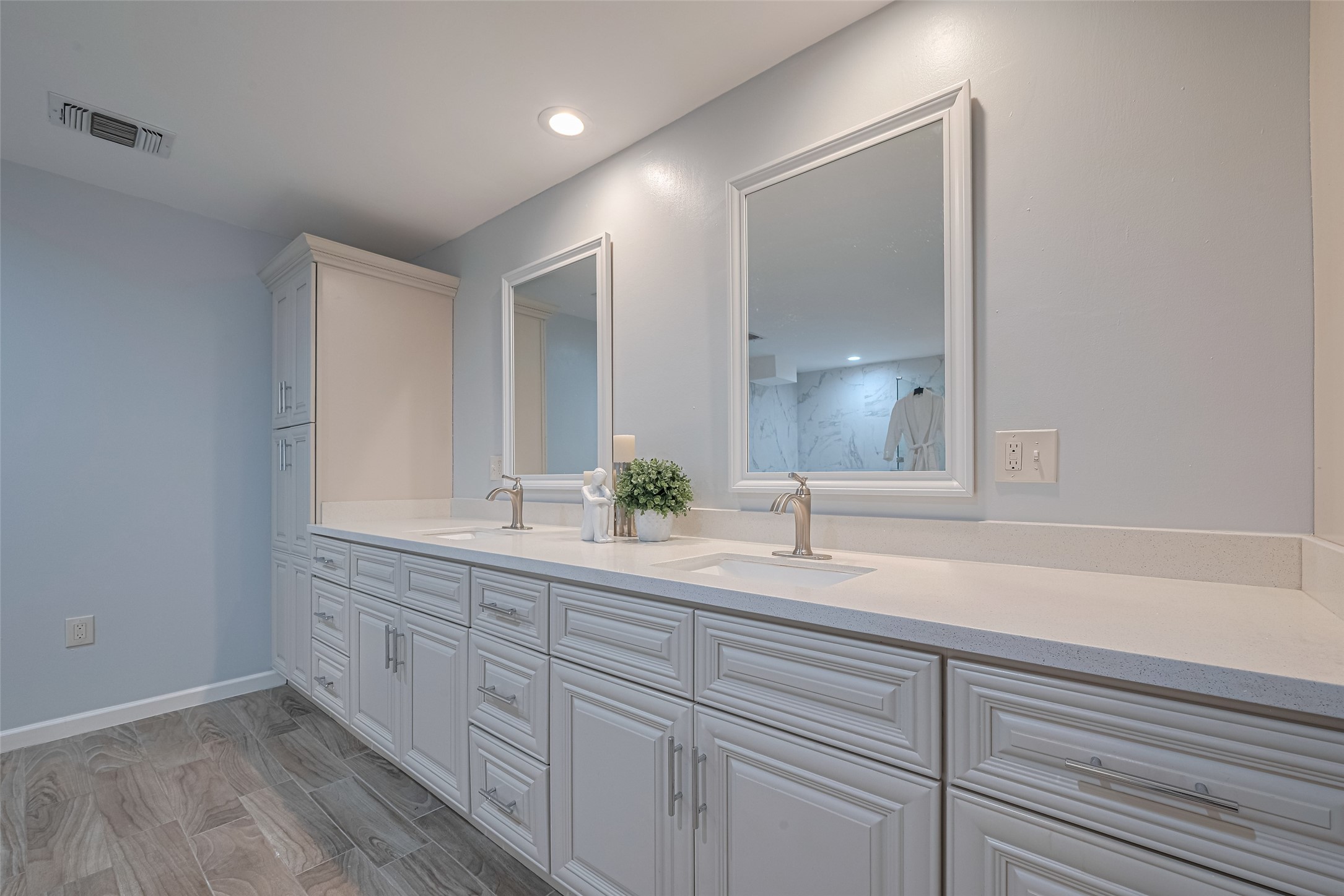 15600 Barkers Landing Road, Unit 20 Houston, TX 77079 - Photo 31 of 49 This bathroom features a dual-sink vanity with elegant faucets, ample storage, and a sleek, modern design. The light color scheme enhances the spacious feel, complemented by modern mirrors.