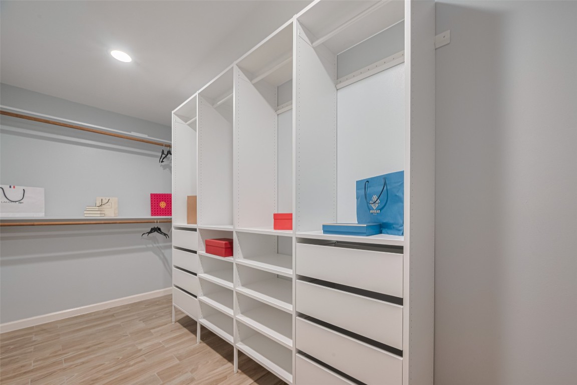 15600 Barkers Landing Road, Unit 20 Houston, TX 77079 - Photo 35 of 49 This spacious walk-in closet features custom shelving and drawers, ample hanging space, and a sleek, modern design. Perfect for organized storage.