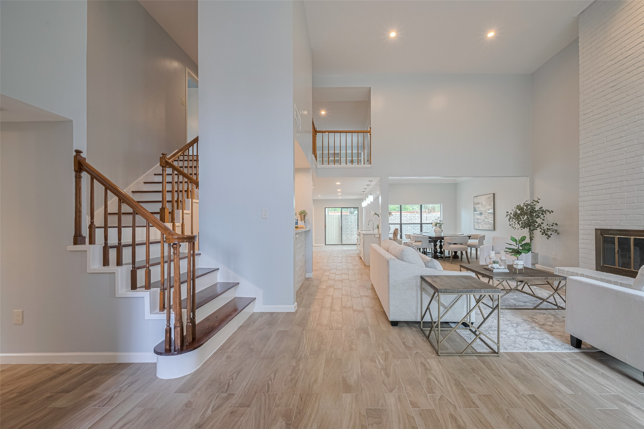 15600 Barkers Landing Road, Unit 20 Houston, TX 77079 - Photo 4 of 49 This open-concept living area features high ceilings, abundant natural light, and a spacious layout. The room includes a cozy fireplace, elegant staircase, and seamless flow into the dining area and kitchen, offering a perfect space for entertaining and family gatherings.