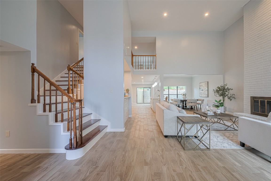 15600 Barkers Landing Road, Unit 20 Houston, TX 77079 - Photo 4 of 49 This open-concept living area features high ceilings, abundant natural light, and a spacious layout. The room includes a cozy fireplace, elegant staircase, and seamless flow into the dining area and kitchen, offering a perfect space for entertaining and family gatherings.