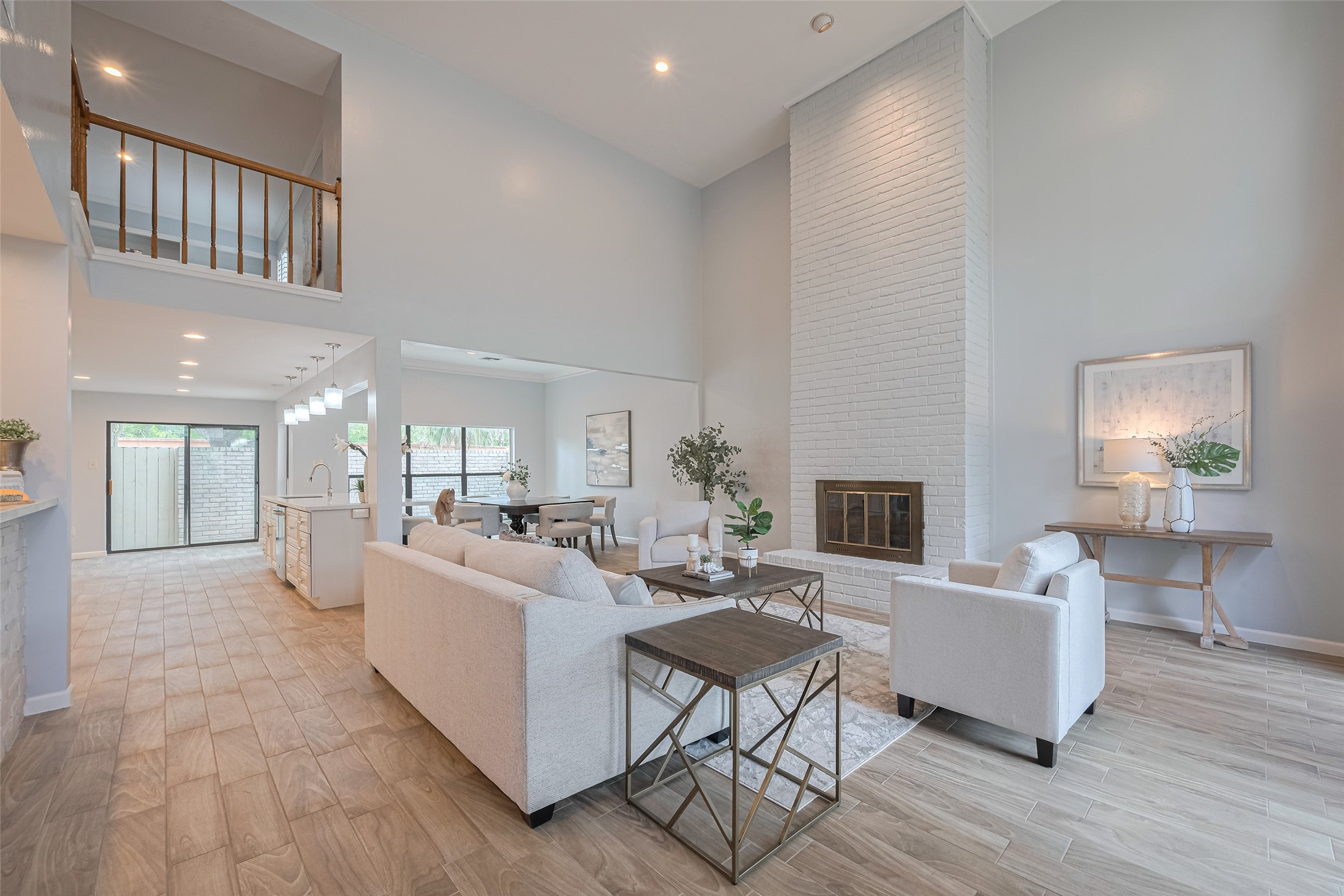 15600 Barkers Landing Road, Unit 20 Houston, TX 77079 - Photo 5 of 49 This spacious living area features high ceilings, a modern open layout, and abundant natural light. The elegant room includes a tall white brick fireplace, and a view into the open kitchen and dining space, creating an inviting and cohesive environment.