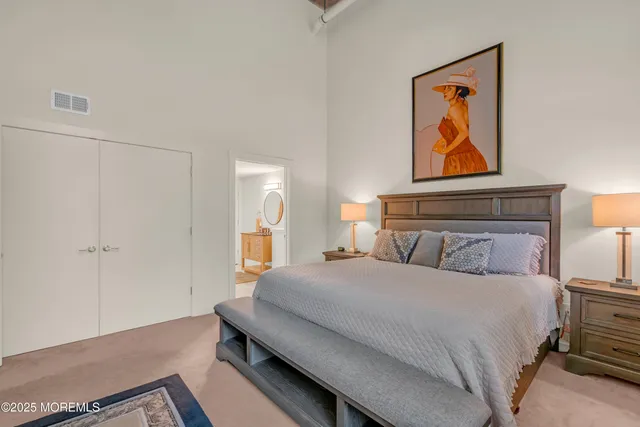 a bedroom with a bed and painting on the wall