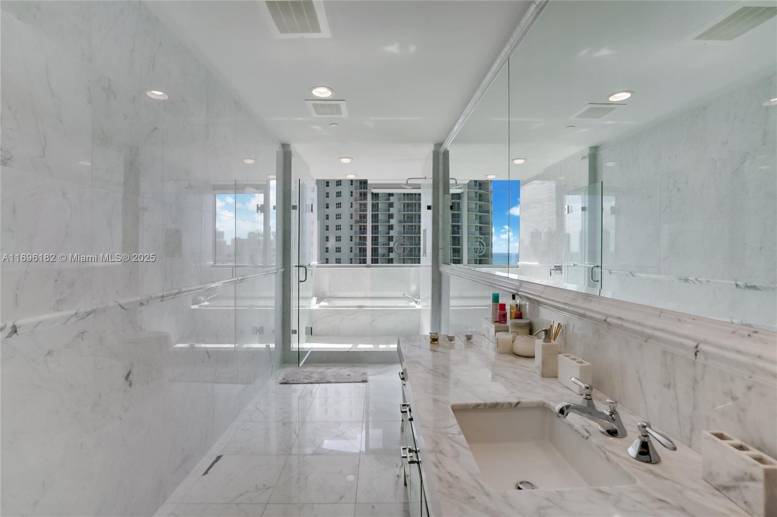 17475 Collins Avenue, Unit 602 Sunny Isles Beach, FL 33160 - Photo 11 of 24 a bathroom with a tub sink and mirror