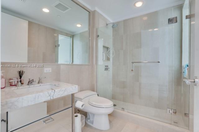 17475 Collins Avenue, Unit 602 Sunny Isles Beach, FL 33160 - Photo 19 of 24 a bathroom with a sink toilet and shower