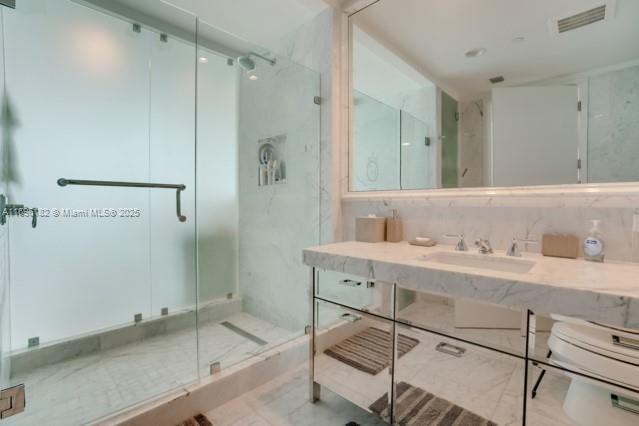 17475 Collins Avenue, Unit 602 Sunny Isles Beach, FL 33160 - Photo 21 of 24 a bathroom with a shower sink and mirror