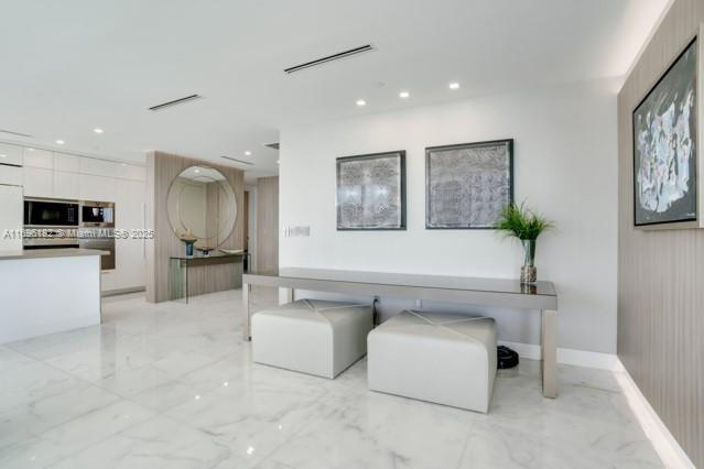 17475 Collins Avenue, Unit 602 Sunny Isles Beach, FL 33160 - Photo 8 of 24 a living room with furniture and kitchen view