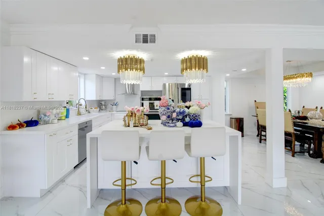 a kitchen with stainless steel appliances kitchen island granite countertop a table and chairs in it