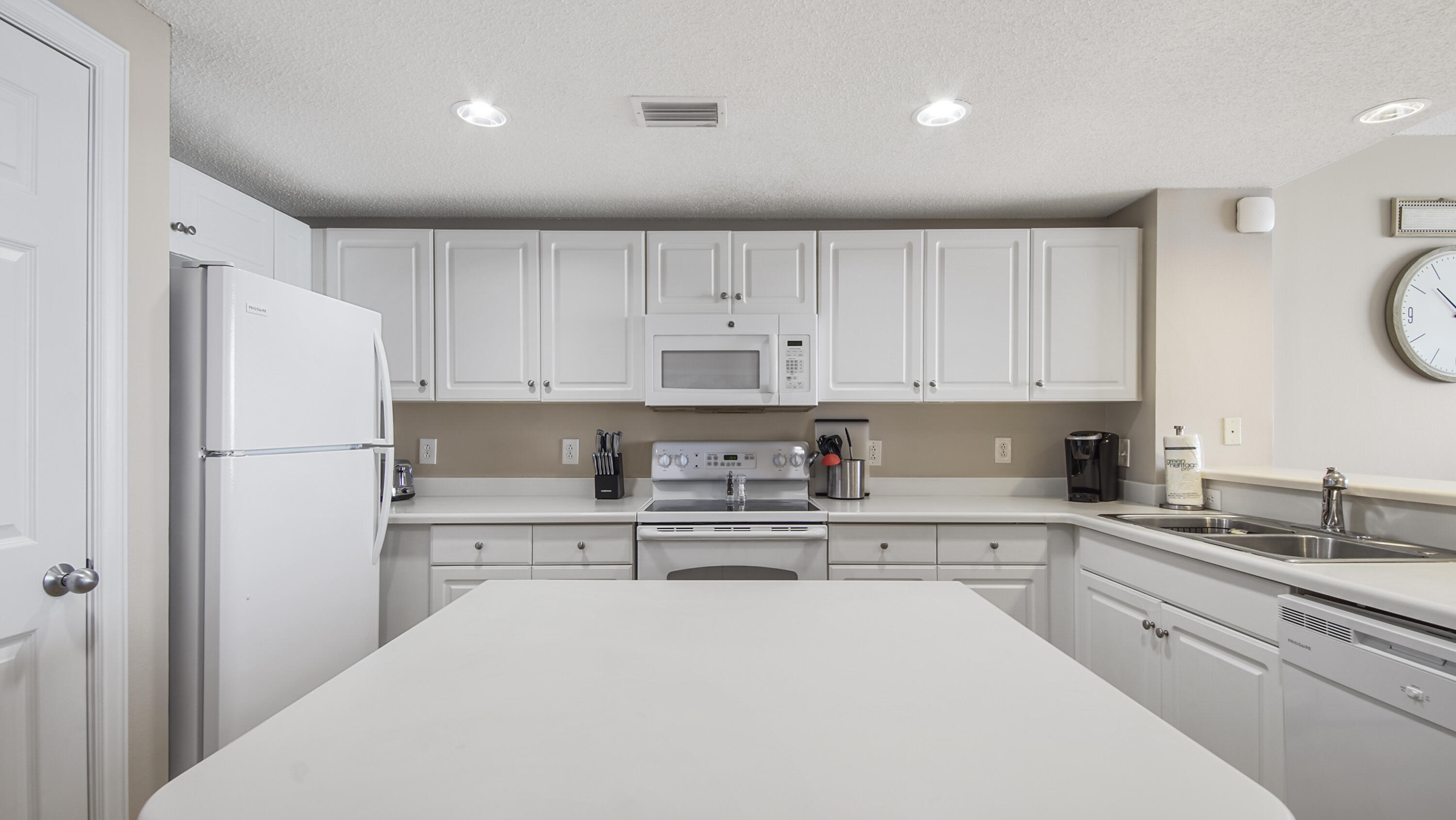 10811 Front Beach Road, Unit 1405 Panama City Beach, FL 32408 - Photo 22 of 76 a kitchen with white cabinets and stainless steel appliances