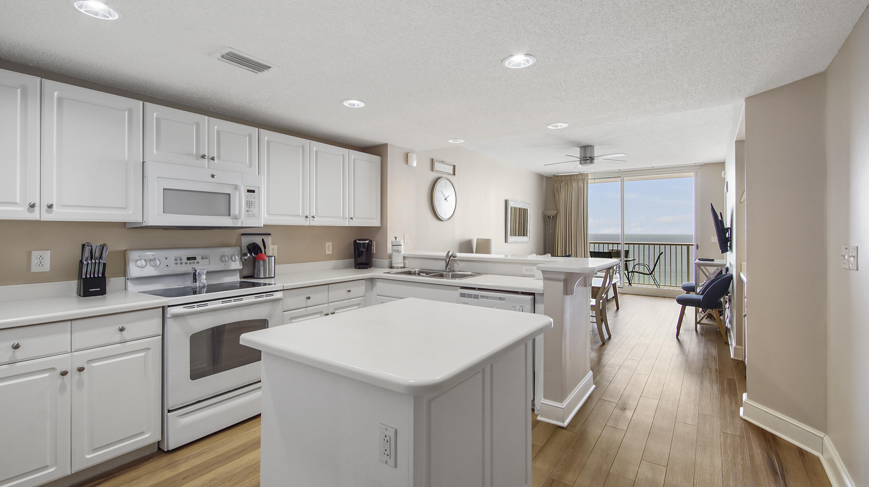 10811 Front Beach Road, Unit 1405 Panama City Beach, FL 32408 - Photo 6 of 76 a kitchen with a sink a stove top oven and white cabinets