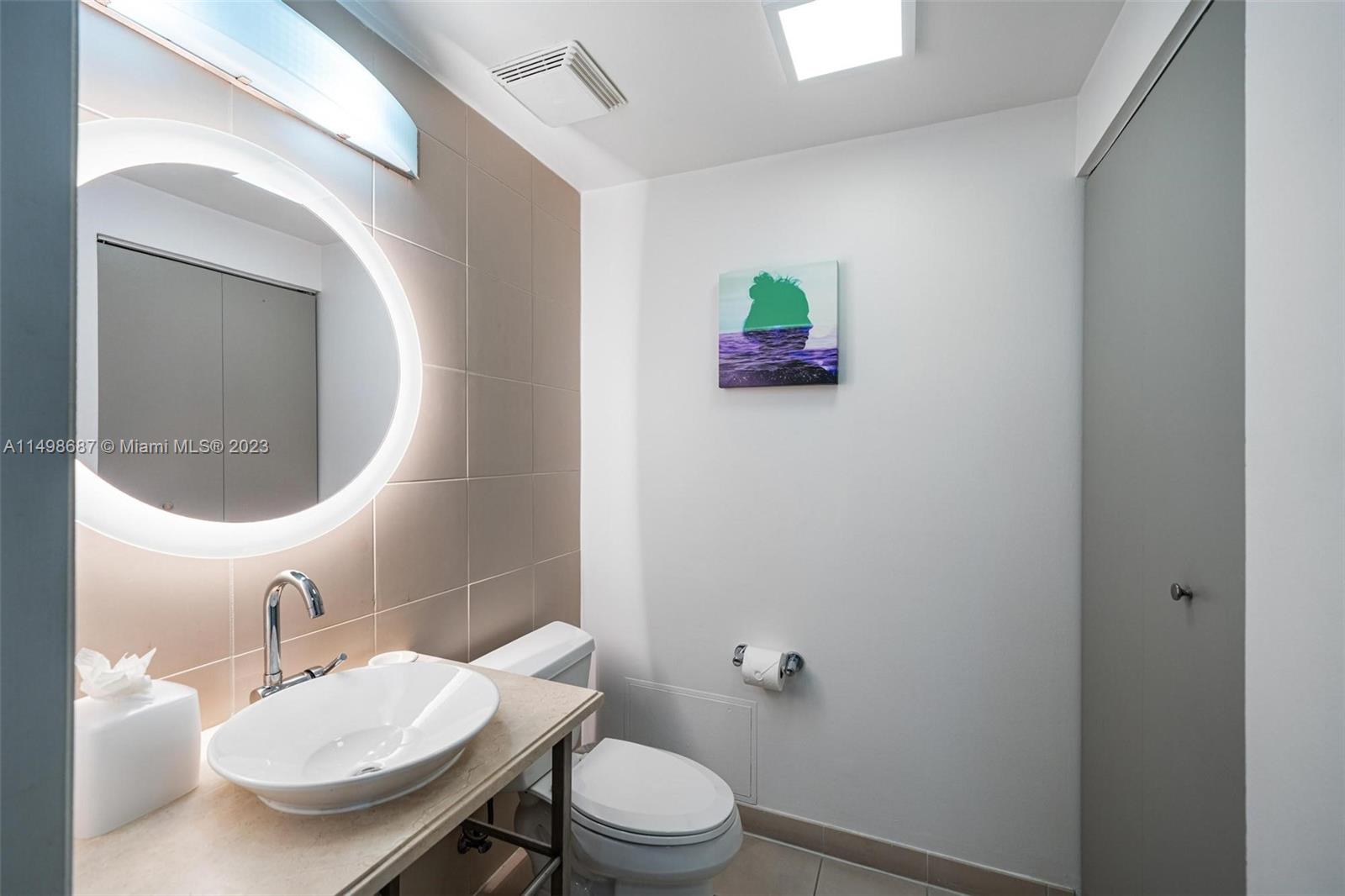 2889 McFarlane Road, Unit 1414 Miami, FL 33133 - Photo 11 of 15 a bathroom with a sink toilet and mirror