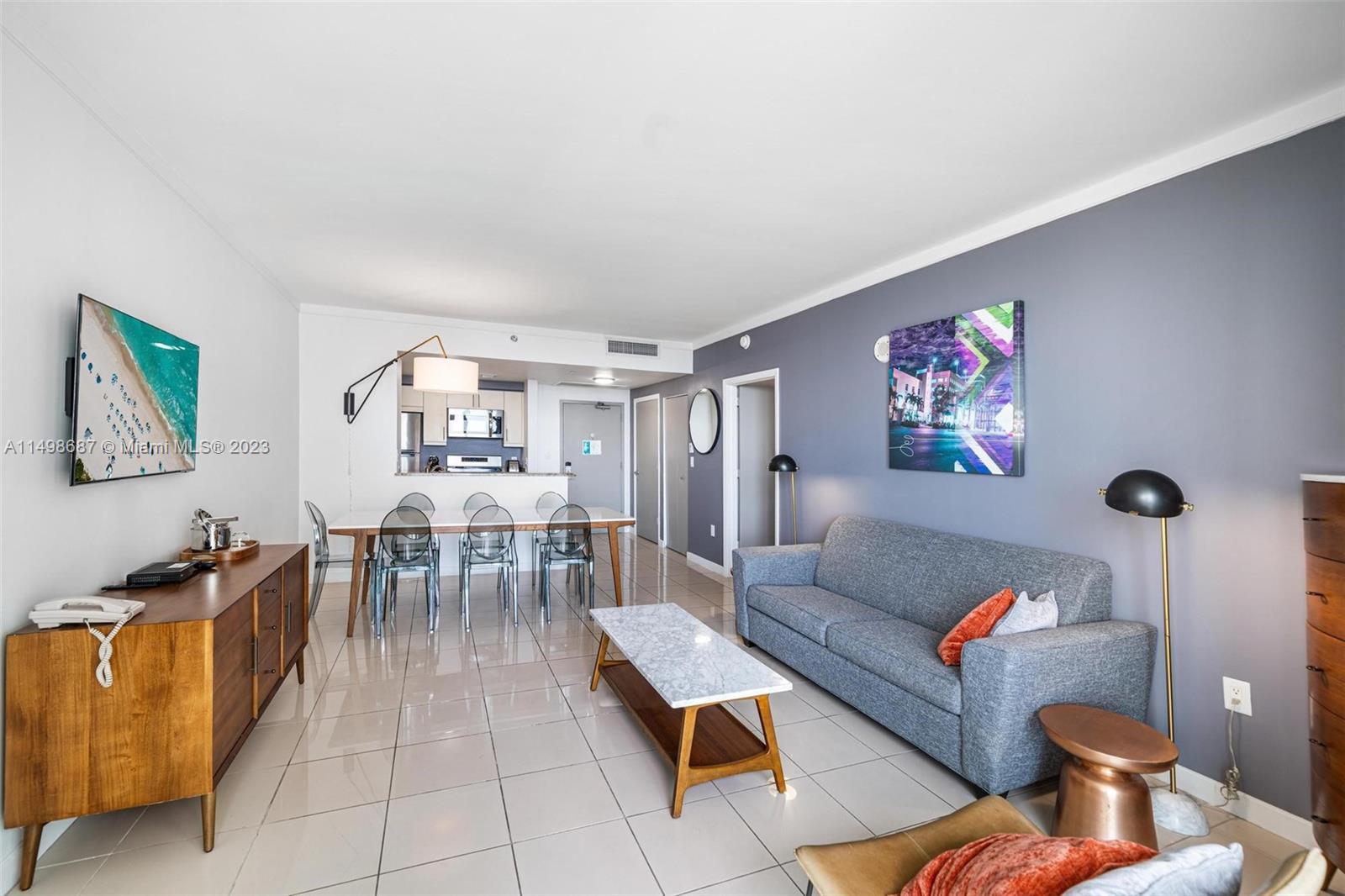 2889 McFarlane Road, Unit 1414 Miami, FL 33133 - Photo 4 of 15 a living room with furniture and a dining table with bookshelf