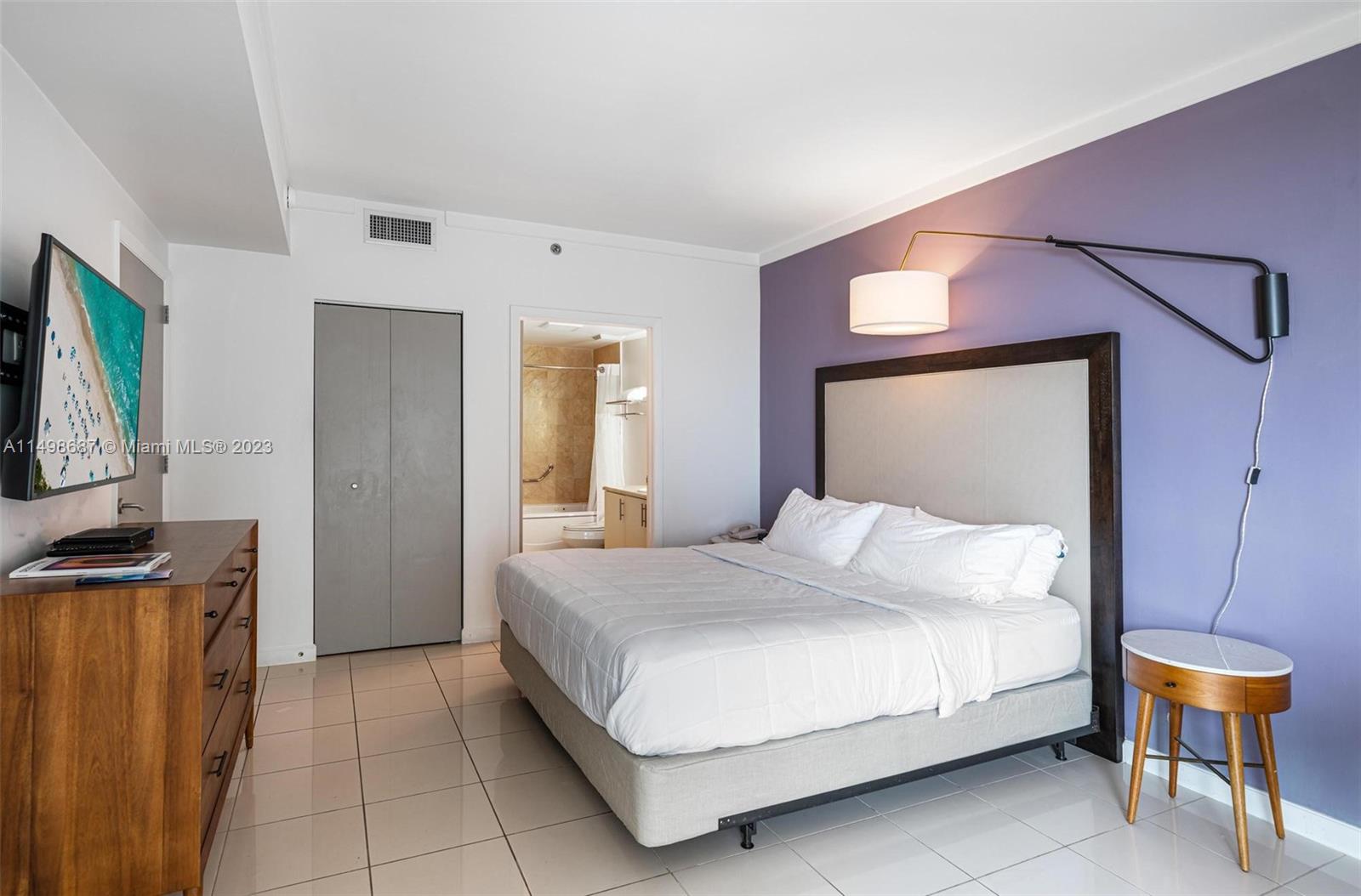 2889 McFarlane Road, Unit 1414 Miami, FL 33133 - Photo 7 of 15 a bedroom with a bed and a flat screen tv