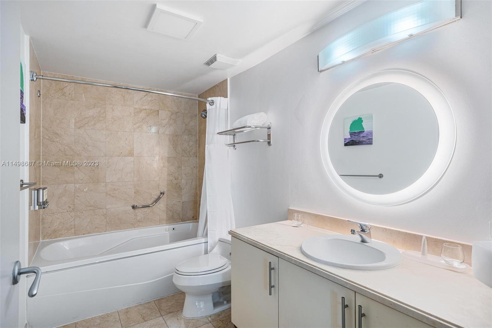 2889 McFarlane Road, Unit 1414 Miami, FL 33133 - Photo 10 of 15 a bathroom with a sink a toilet and a mirror