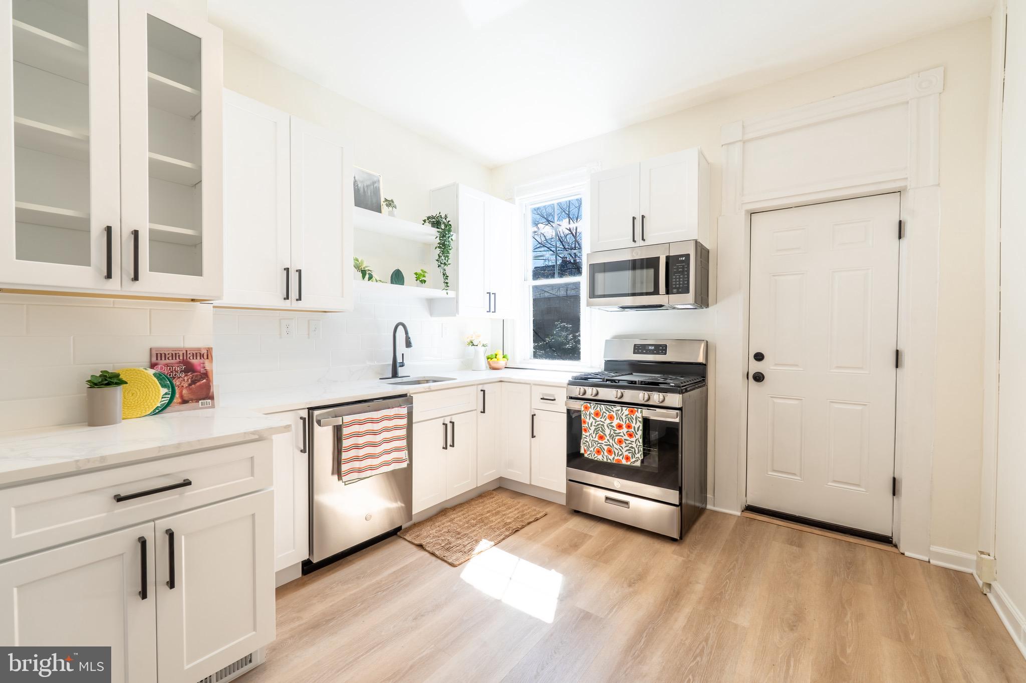 511 East 35th Street Baltimore, MD 21218 - Photo 5 of 19 a kitchen with stainless steel appliances and white cabinets