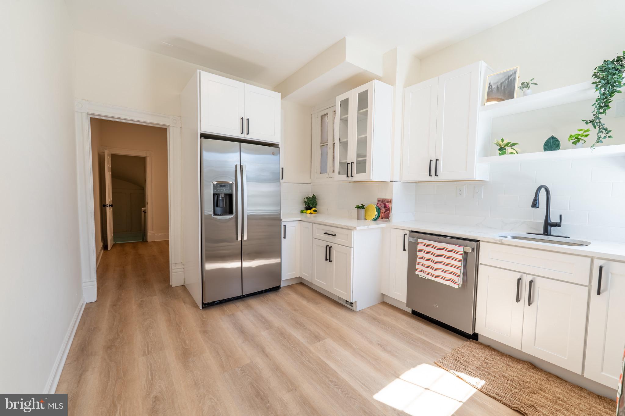 511 East 35th Street Baltimore, MD 21218 - Photo 6 of 19 a kitchen with stainless steel appliances a refrigerator sink and white cabinets