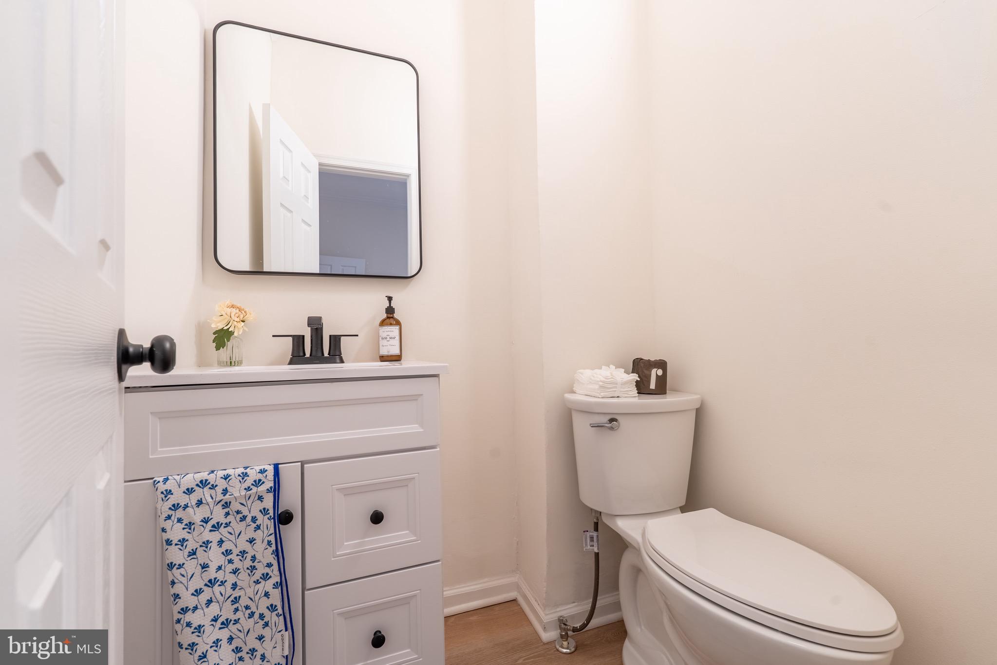 511 East 35th Street Baltimore, MD 21218 - Photo 8 of 19 a bathroom with a toilet a sink a vanity and mirror