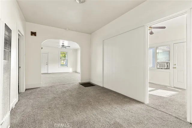 an empty room that has a large window and wooden floor