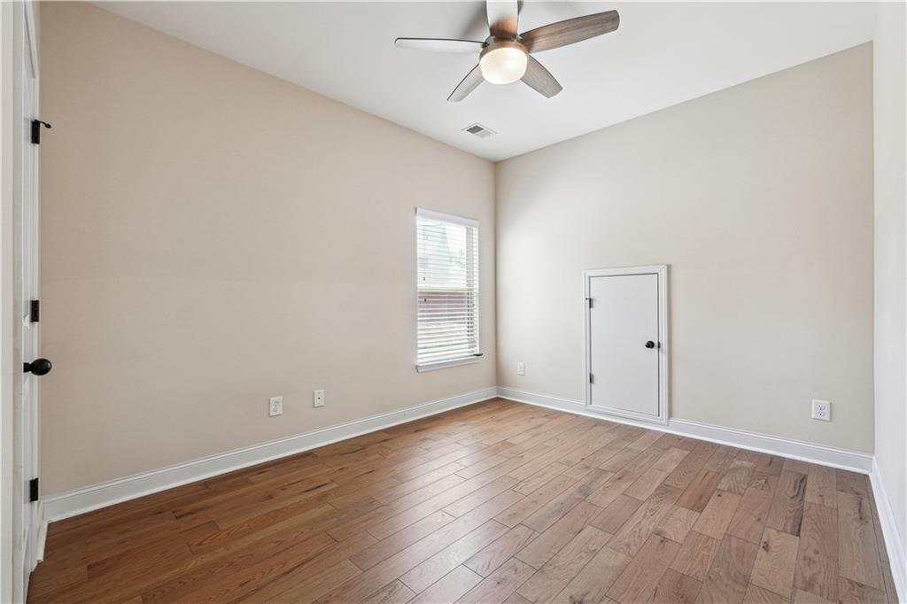 5145 Rialto Way Cumming, GA 30040 - Photo 21 of 25 a view of an empty room with wooden floor and a window