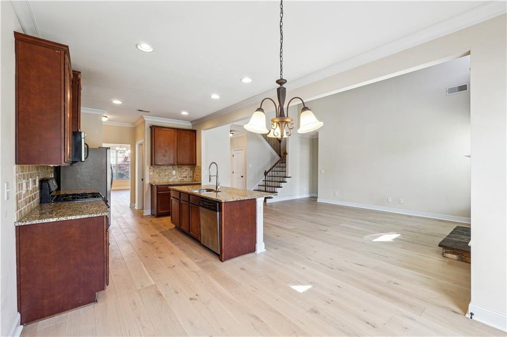 5145 Rialto Way Cumming, GA 30040 - Photo 6 of 25 a large kitchen with kitchen island a large counter top appliances and cabinets