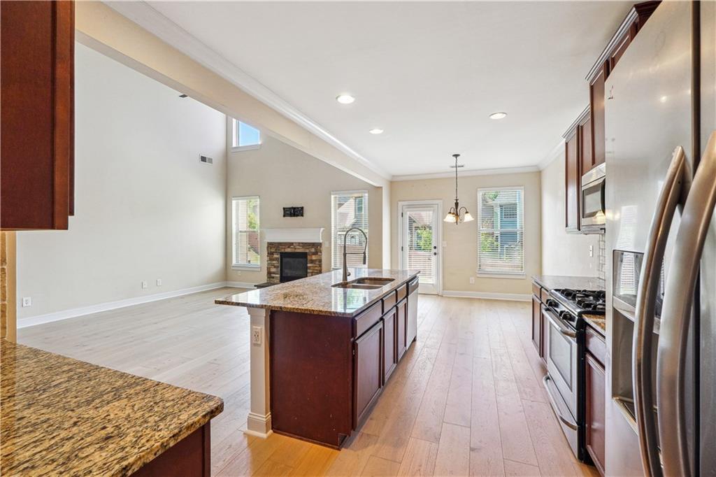 5145 Rialto Way Cumming, GA 30040 - Photo 9 of 25 a open kitchen with stainless steel appliances granite countertop a stove oven and a refrigerator