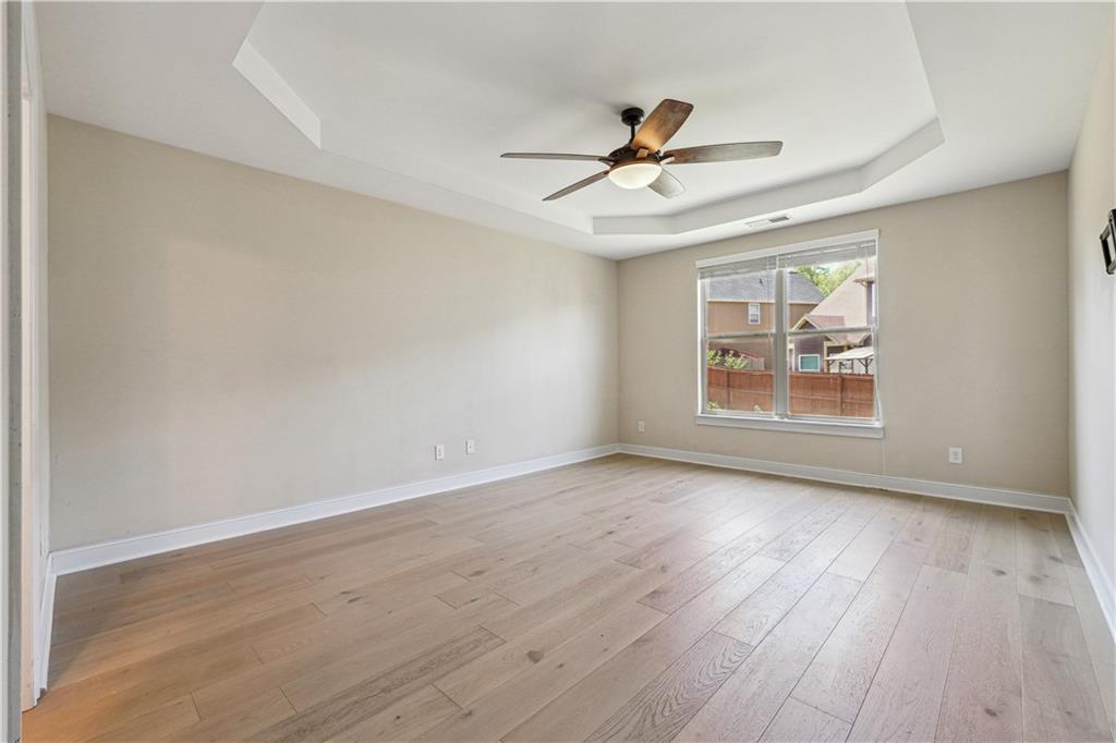 5145 Rialto Way Cumming, GA 30040 - Photo 10 of 25 a view of an empty room with wooden floor and a window