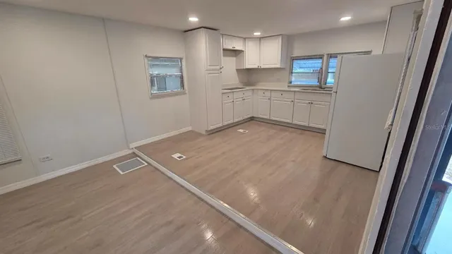 a view of a kitchen with a refrigerator cabinets and wooden floor