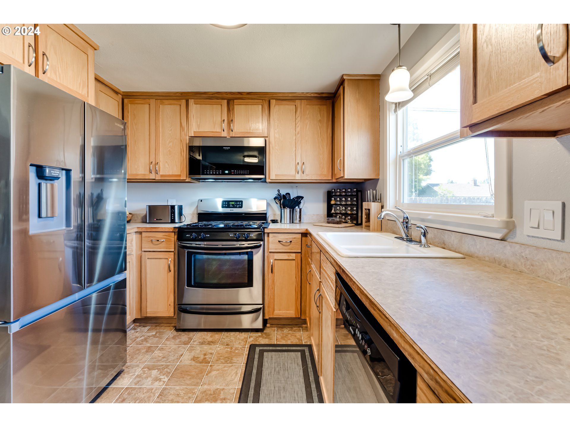 3715 Harlow Road Eugene, OR 97401 - Photo 17 of 39 a kitchen with stainless steel appliances a stove a sink a microwave and cabinets
