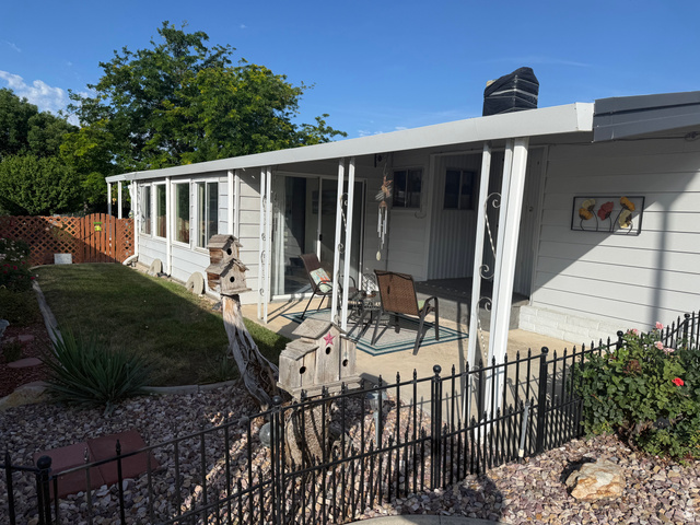77 West Alta View Way Sandy, UT 84070 - Photo 22 of 43 Exterior featuring light-toned siding, a covered patio area, and an enclosed sunroom with multiple windows