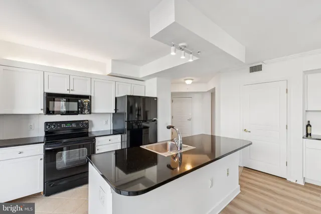 a kitchen with stainless steel appliances granite countertop a sink refrigerator and microwave