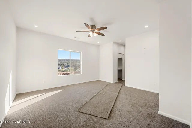 an empty room with fan and windows