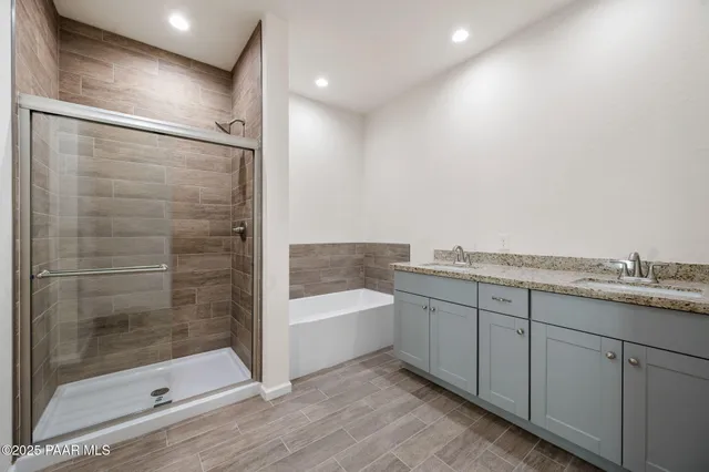 a bathroom with a granite countertop bathtub shower sink and mirror