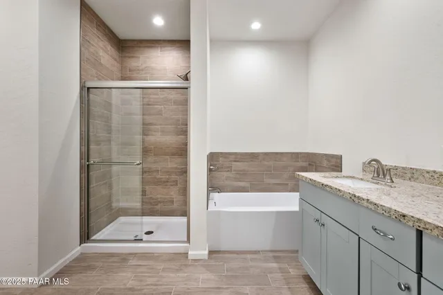 a bathroom with a granite countertop sink a toilet and shower
