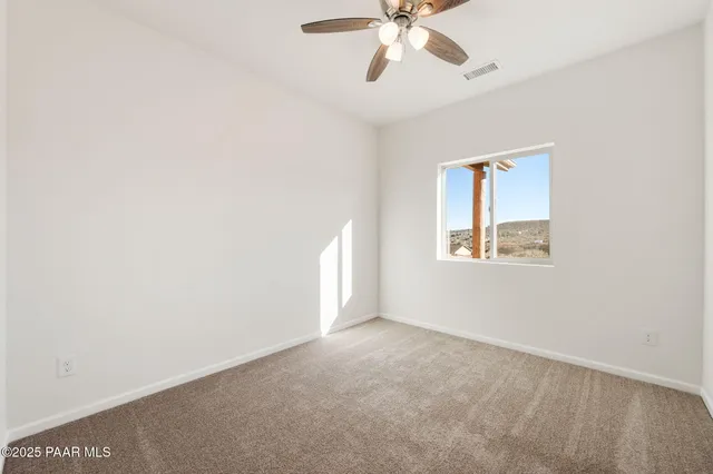 an empty room with a window and a fan