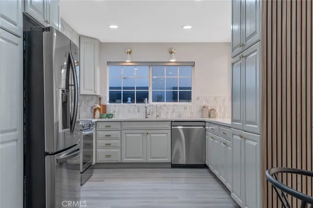 a kitchen with stainless steel appliances granite countertop a refrigerator and a sink