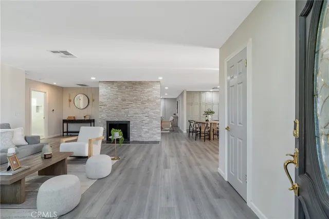 a living room with furniture a fireplace and kitchen view