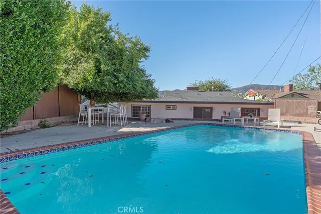 a swimming pool view with a seating space