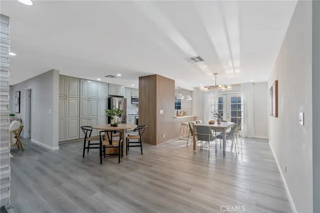 a dining room with furniture wooden floor a rug and a painting