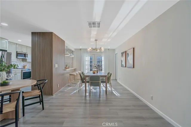 a dining room with furniture a chandelier and wooden floor
