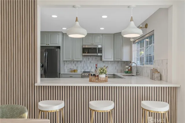a kitchen with stainless steel appliances a white table and chairs